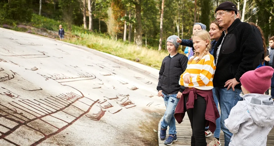 En grupp människor vid en hällristning.