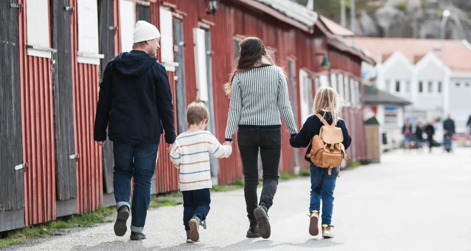 En grupp människor som går längs en gata och håller varandra i handen.