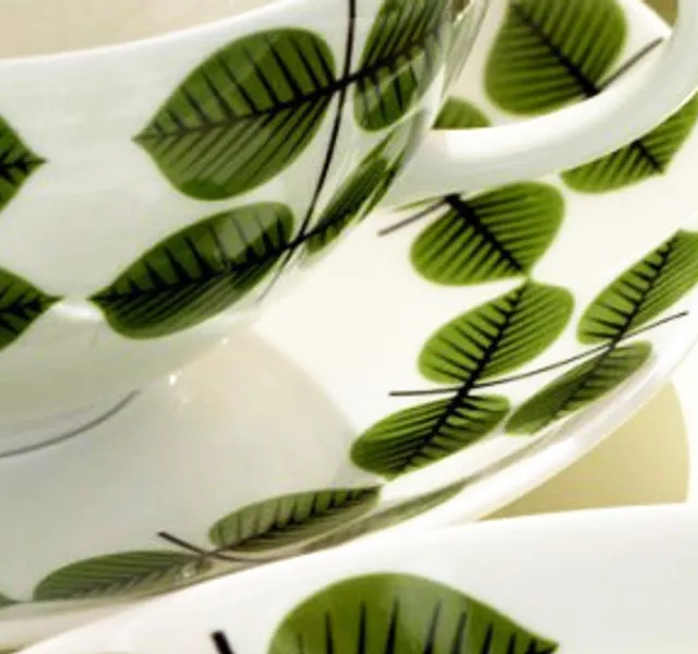 En närbild av en kopp och ett fat på ett bord.