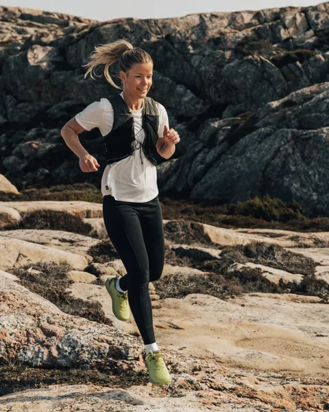 Kvinna tränar ute i naturen.