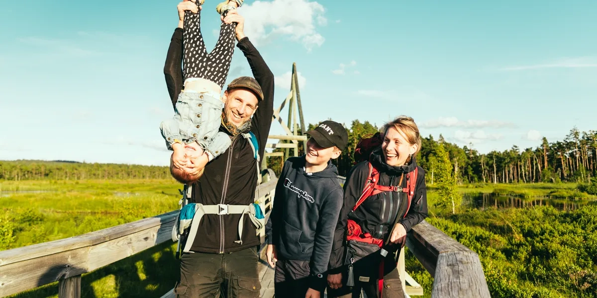 En grupp människor som står på toppen av en träbro.