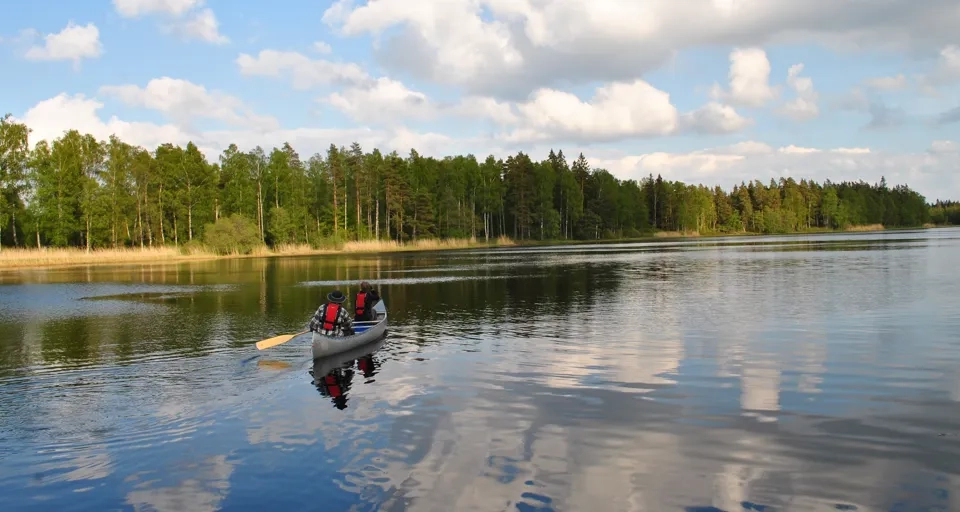 En person i en liten båt på en sjö.