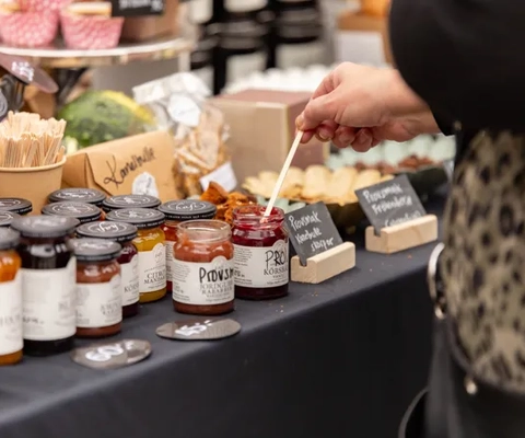 Ett bord med en mängd olika sylter och kryddor på.