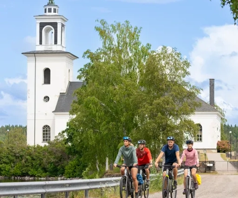 En grupp människor som cyklar längs en väg.
