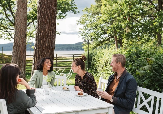 En grupp människor som sitter runt ett vitt bord.
