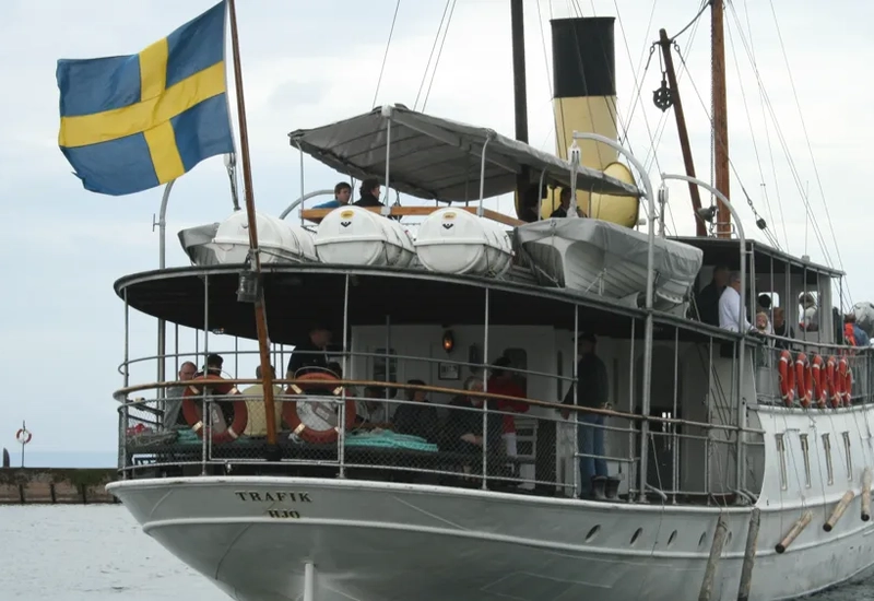 A large white boat with a flag on top of it.