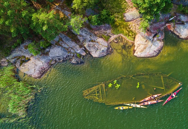Ett vrak som ligger nära land i vattnet. Det syns ovanifrån.