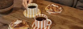 Kvinna håller i en kopp på ett kafé.