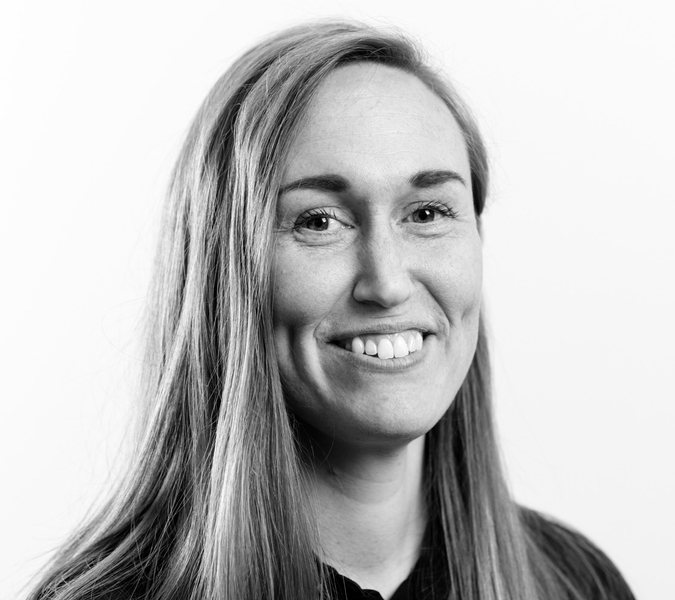A black and white photo of a woman smiling.