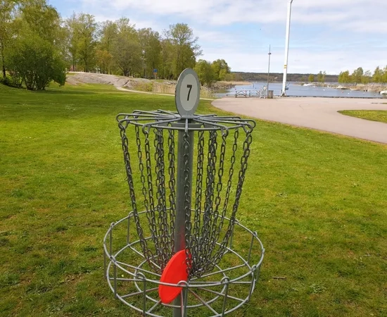 En frisbeegolfbur med en röd frisbee i.