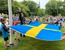 En man håller en stor drake i en park.