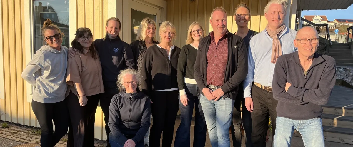 En grupp människor, styrelsen Destination Skaftö, står framför Solrosen i Krögen.