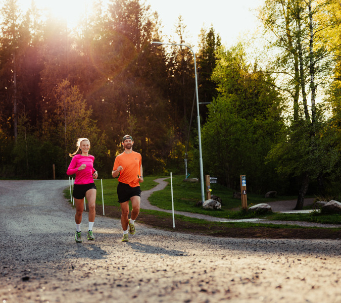 Två personer som springer på ett grusat motionsspår