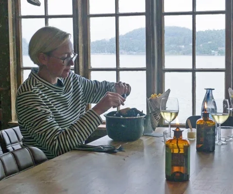 A woman sitting at a table with a bowl of food.