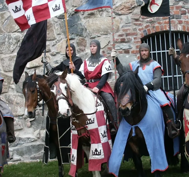 En grupp människor klädda i medeltida dräkter på hästar