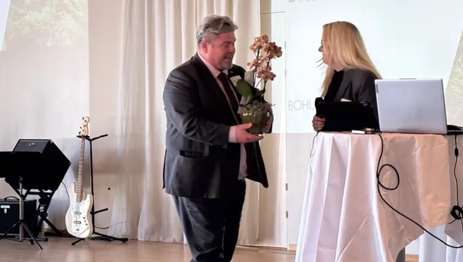 En man i kostym håller i en blombukett.