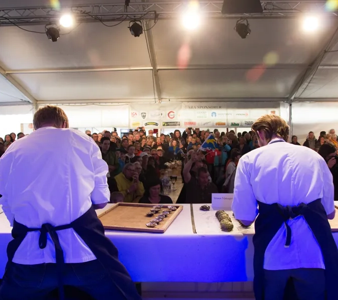 Några män som står bredvid varandra inför en folkmassa.