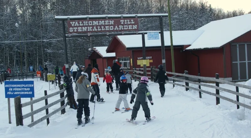 A group of people riding skis on top of snow covered ground.