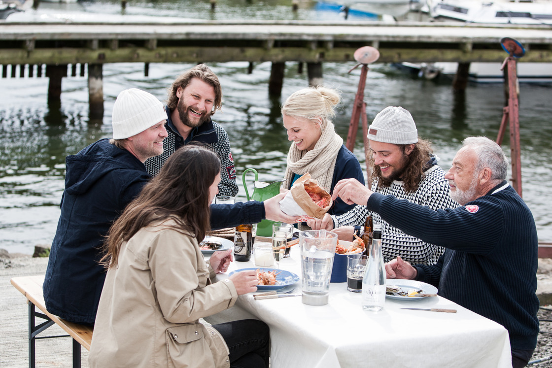 En grupp människor som sitter runt ett bord och äter skaldjur.