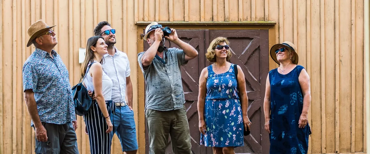 A group of people standing in front of a wooden building.