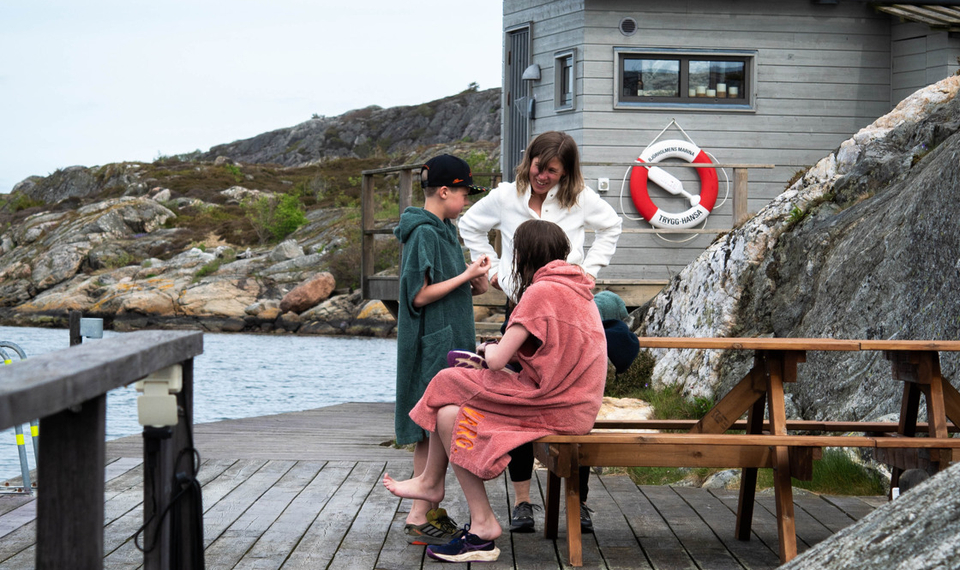 Barn i badrockar på bryggan vid bastun på Björholmen Hotell & Restaurang