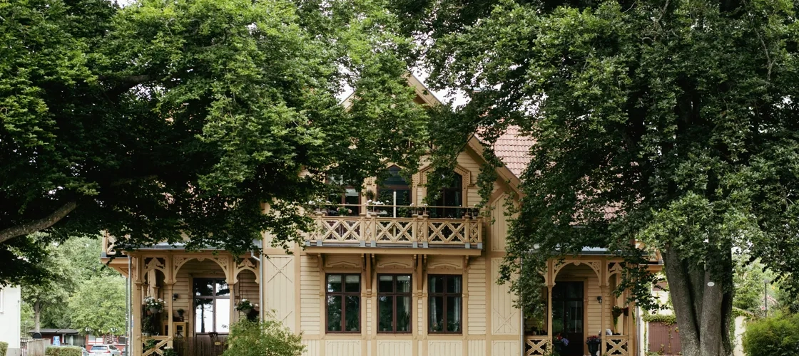 Ein kleines Haus mit einer Veranda und einem Balkon.