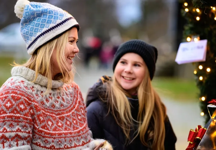 Två tjejer promenerar på julmarknad