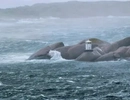 En fyr på en klippa mitt ute i havet.