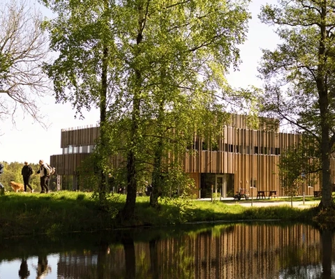 Byggnad som speglar sig i vattnet.