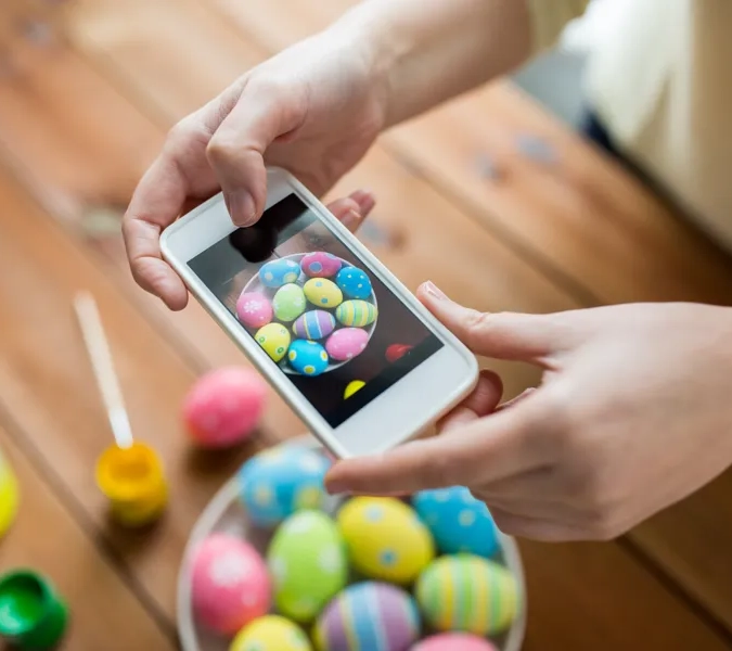 En person som håller en smart telefon över en skål med godis.