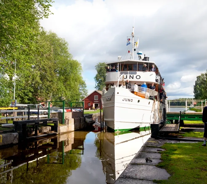 A white boat is docked at a dock.