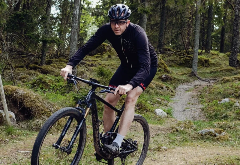 Ein Mann fährt auf einem Fahrrad einen Feldweg hinunter.