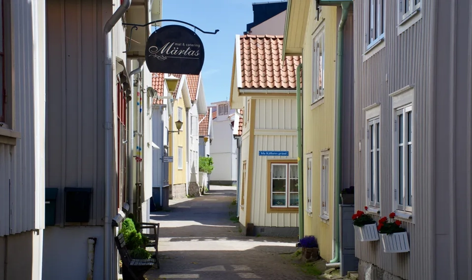 En smal gata med en skylt på sidan av den.