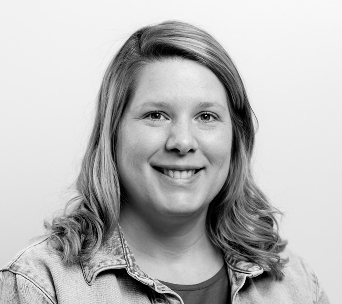 A black and white photo of a woman smiling.