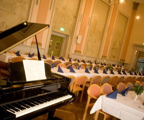 En flygel sitter i mitten av en bankettsal.