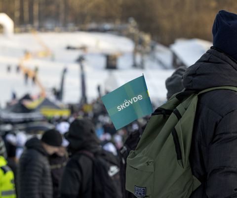 A crowd of people standing on top of a snow covered slope.