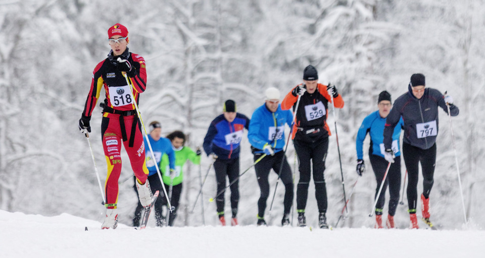 A group of people riding skis down a snow covered slope.