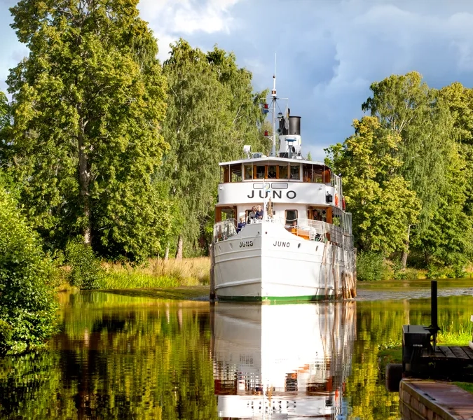 A large white boat floating on top of a lake.