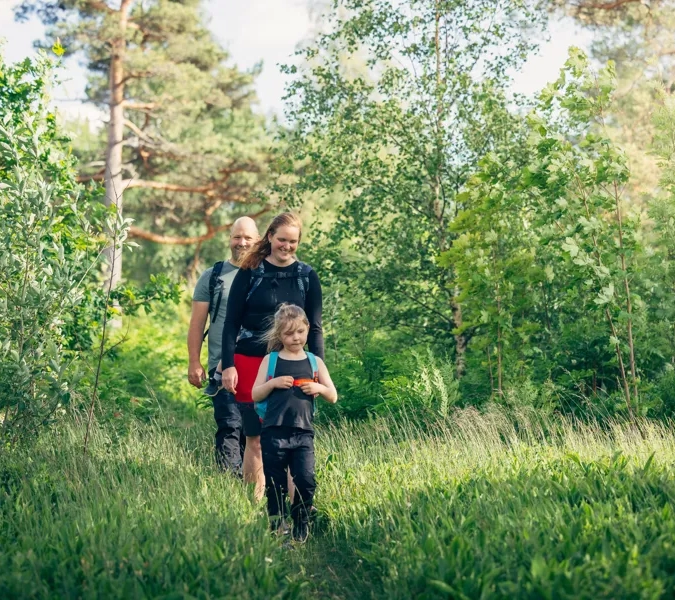 En kvinna och ett barn går genom en skog.