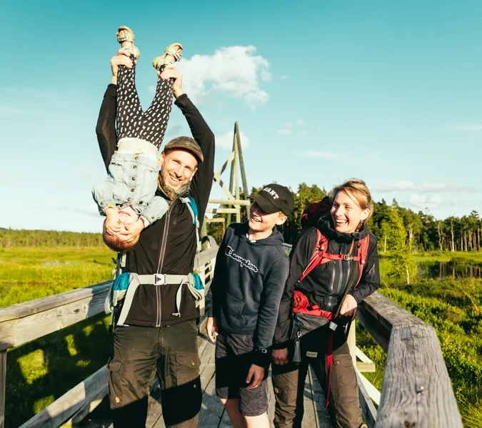 En grupp människor som står på toppen av en träbro.