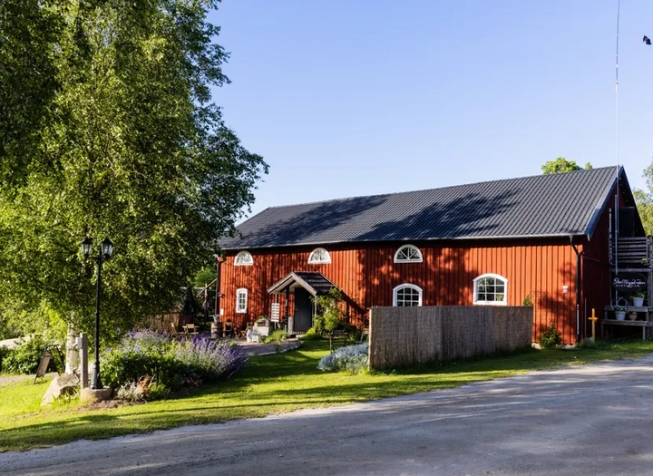 En röd lada står vid sidan av en väg.