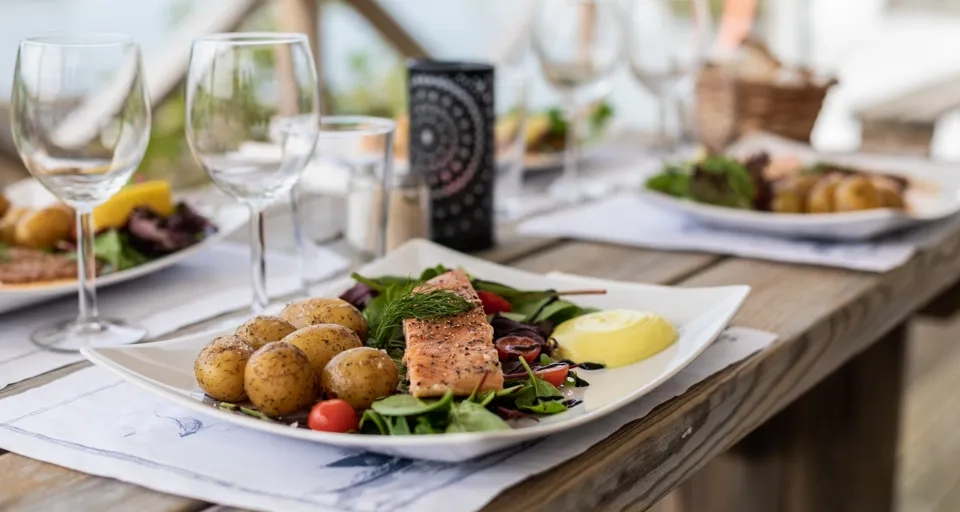 A wooden table topped with plates of food.
