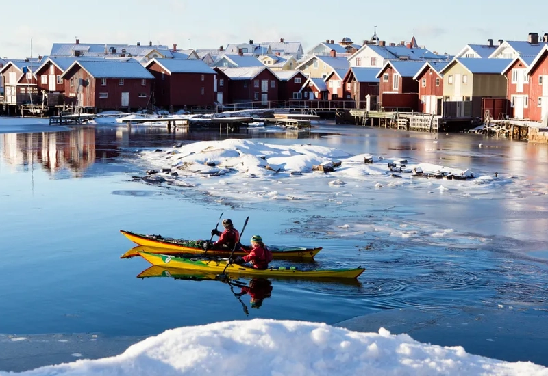 A couple of people in a yellow kayak on a body of water.
