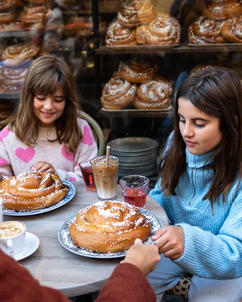 Eine Gruppe von Mädchen sitzt an einem Tisch mit Kanelbulle.