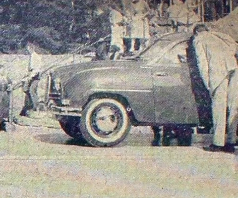 En grupp människor som står runt en bil.