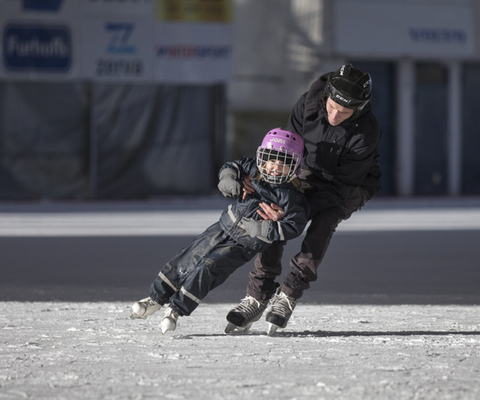 A man and a little girl iceskating toghether