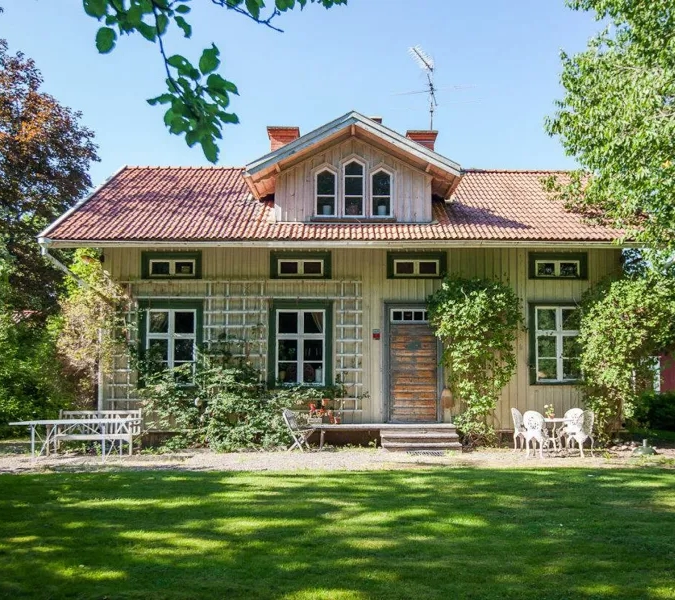 A white house with a red roof surrounded by trees.