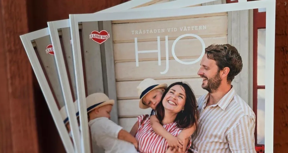 Eine Person, die eine Zeitschrift mit einem Familienfoto in der Hand hält.