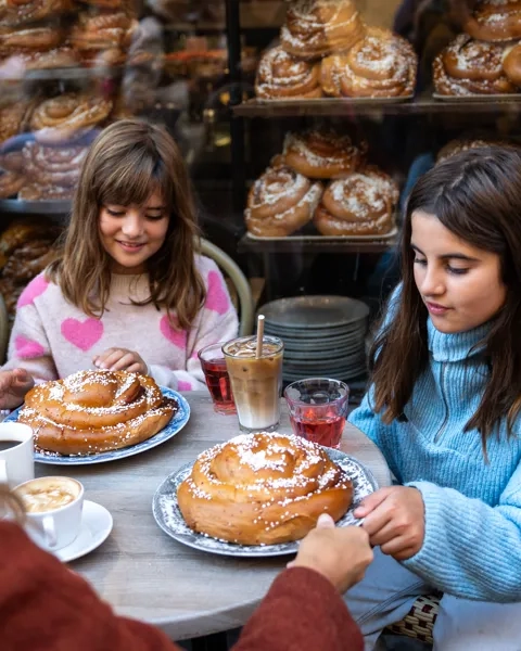 two girls eating cinnamon buns