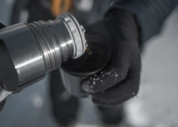 En person häller upp varmdryck i en mugg från en termos en vinterdag.